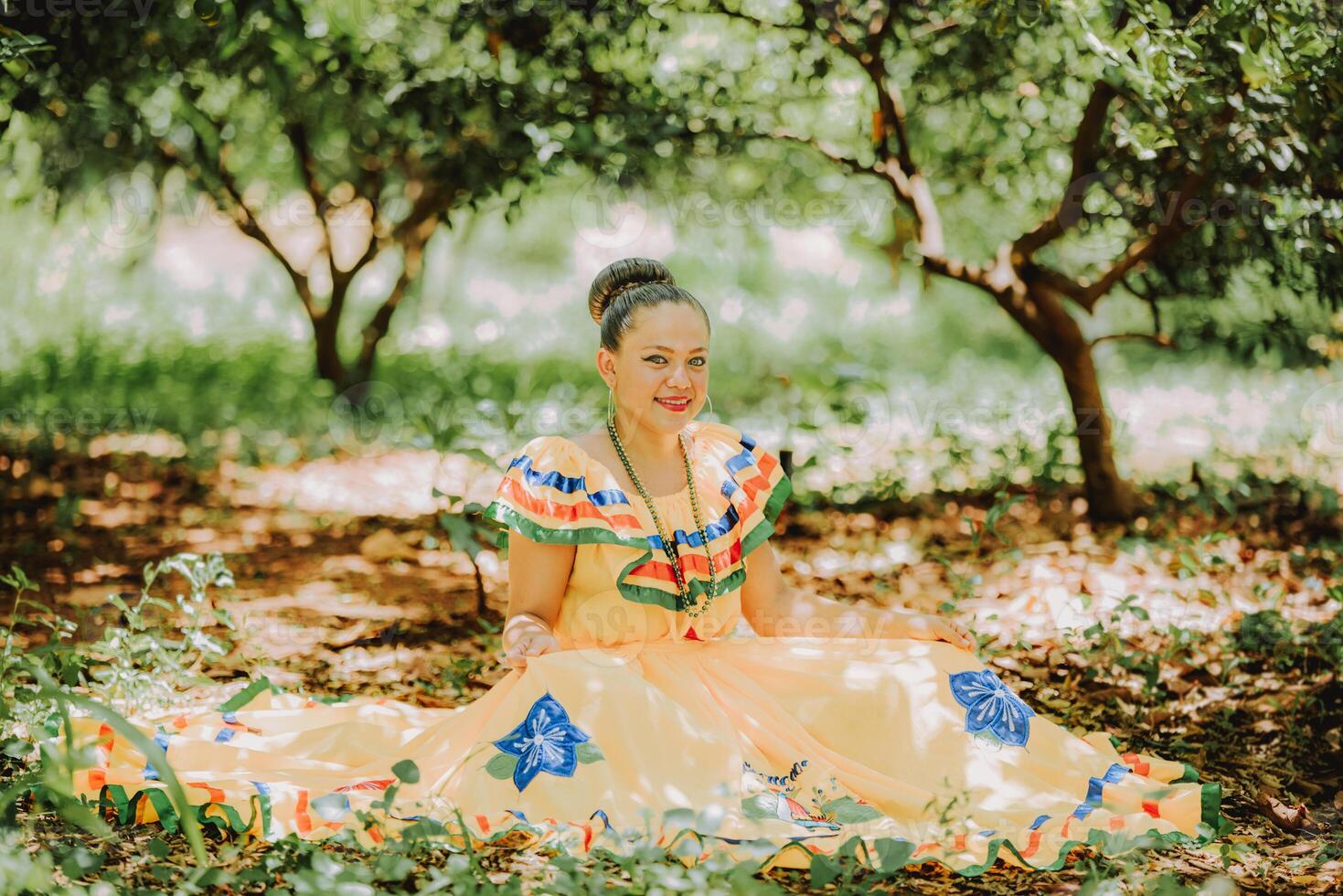 Happy girl in national folk costume sitting on the grass photo