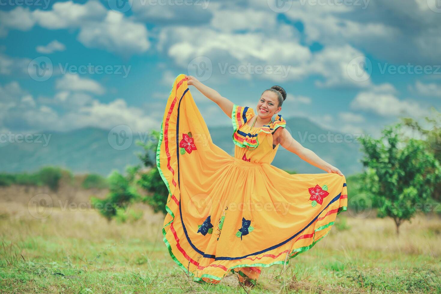 Hispanic girl in national folk costume in a field smiling at camera photo