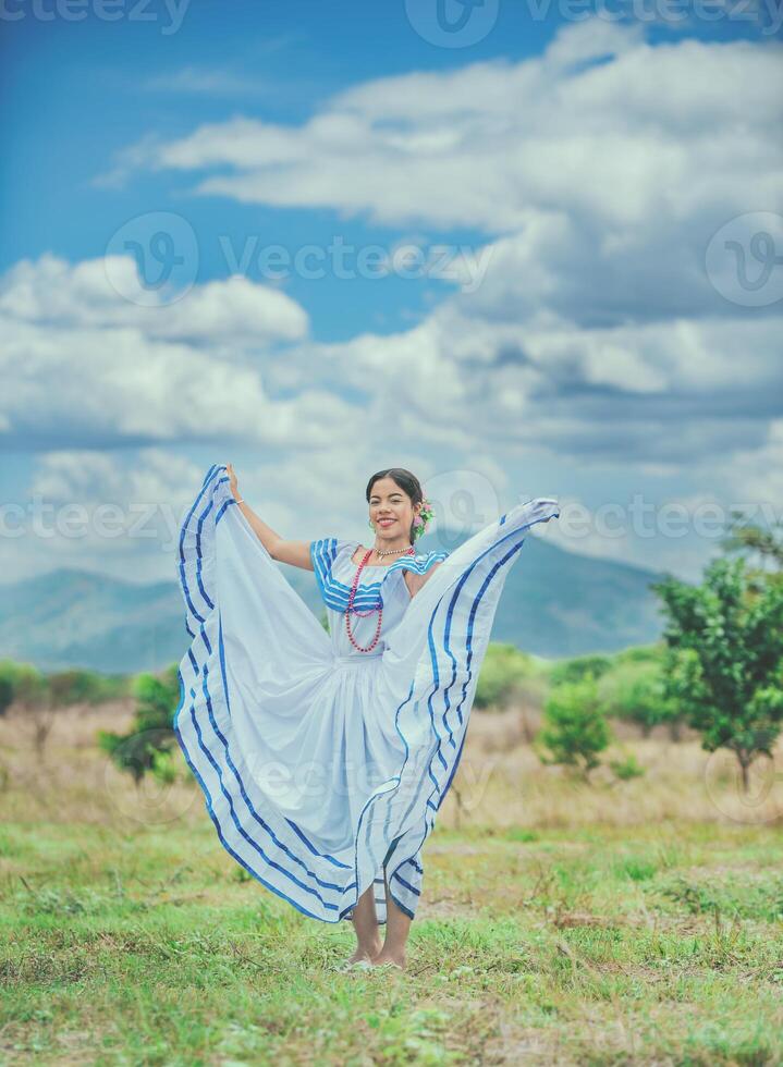 Woman wearing traditional Nicaraguan folk costume in a field. Smiling girl in national folk costume in the field photo