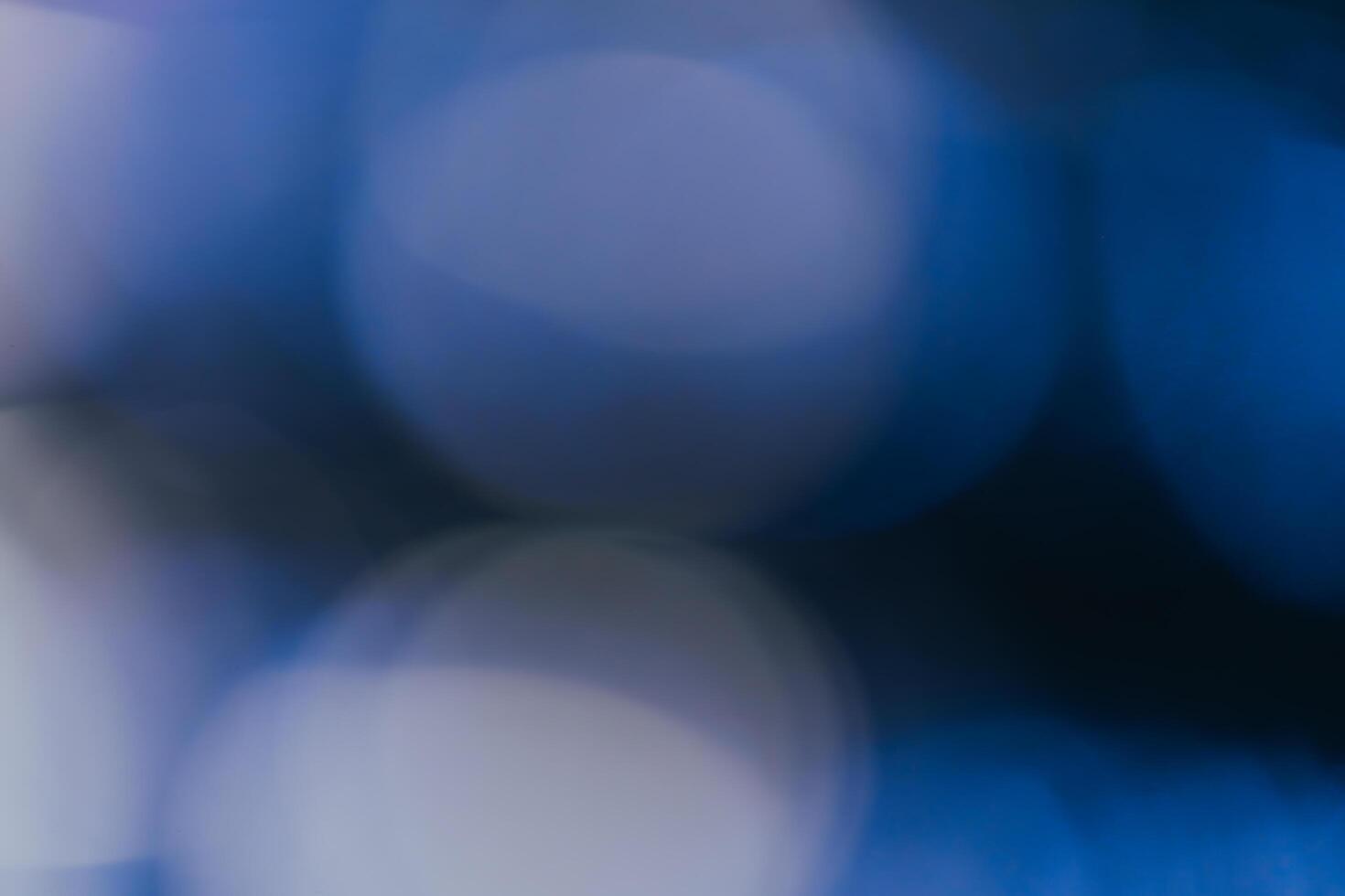 Blue background created in camera with a macro lens with overlapping bokeh circular shapes soft edges light and dark areas with room for copy and text. photo