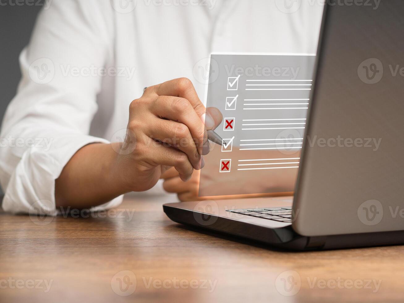 Businessman is making a checkmark and a cross symbol on a document management system or DMS on a virtual screen photo