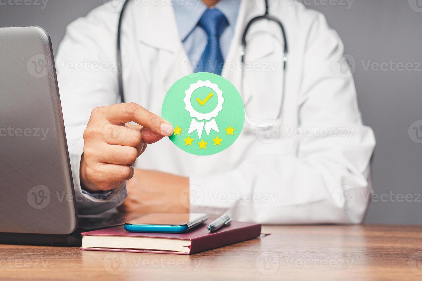 Doctor holding a quality assurance symbol while sitting in the hospital. photo