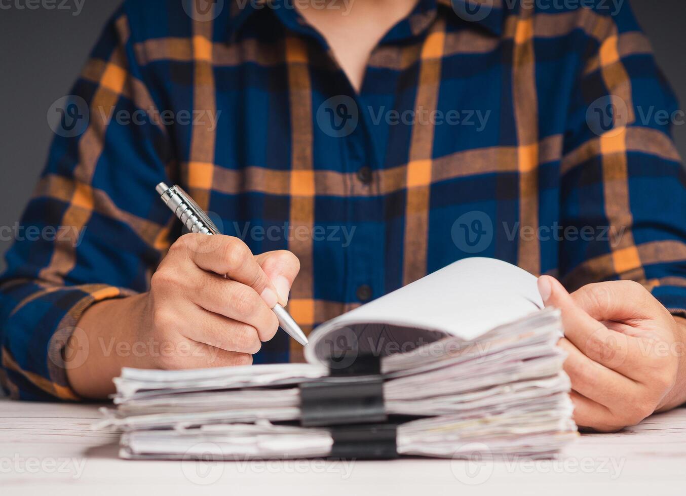 Close-up of hand signing a lease contract or agreement while sitting at the table in the office. photo