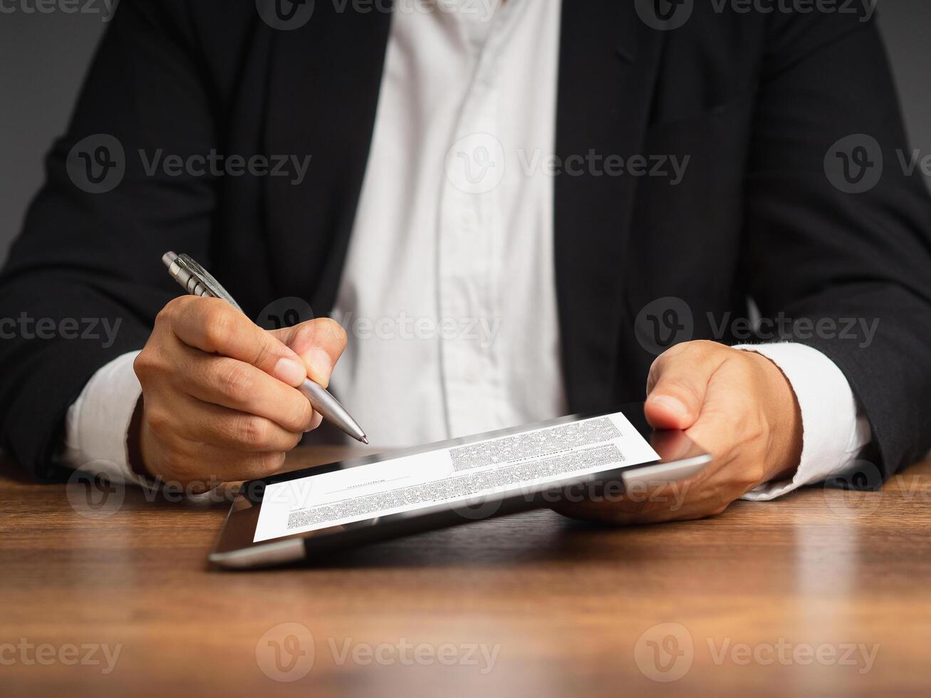 Businesswoman signing a digital contract or agreement on a tablet while sitting in the office photo