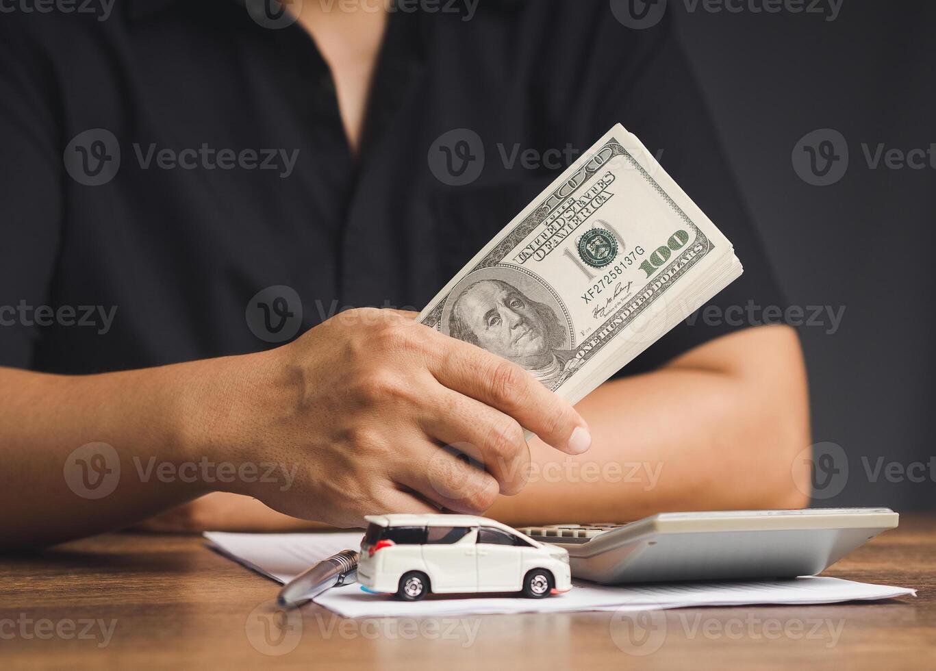 Car loan or Title loan. US dollar bills in a hand businessman while sitting at the table photo