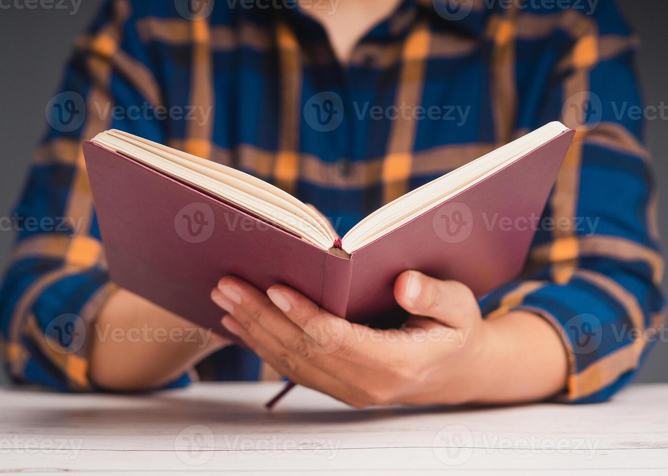 A man reading a book while sitting at the table photo