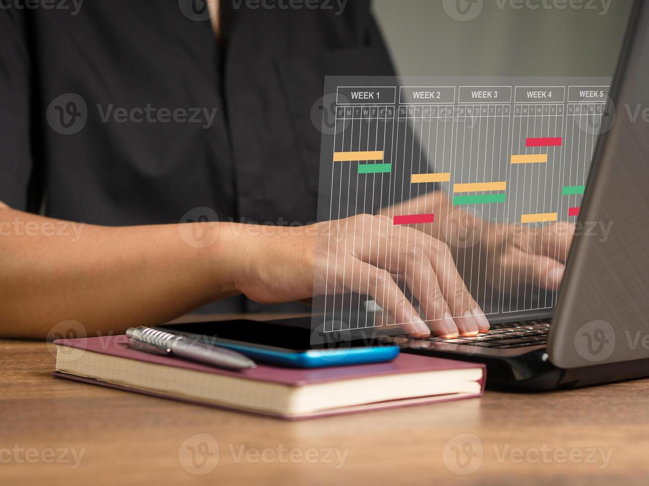 Project manager working on a laptop and updating tasks and milestones progress planning photo
