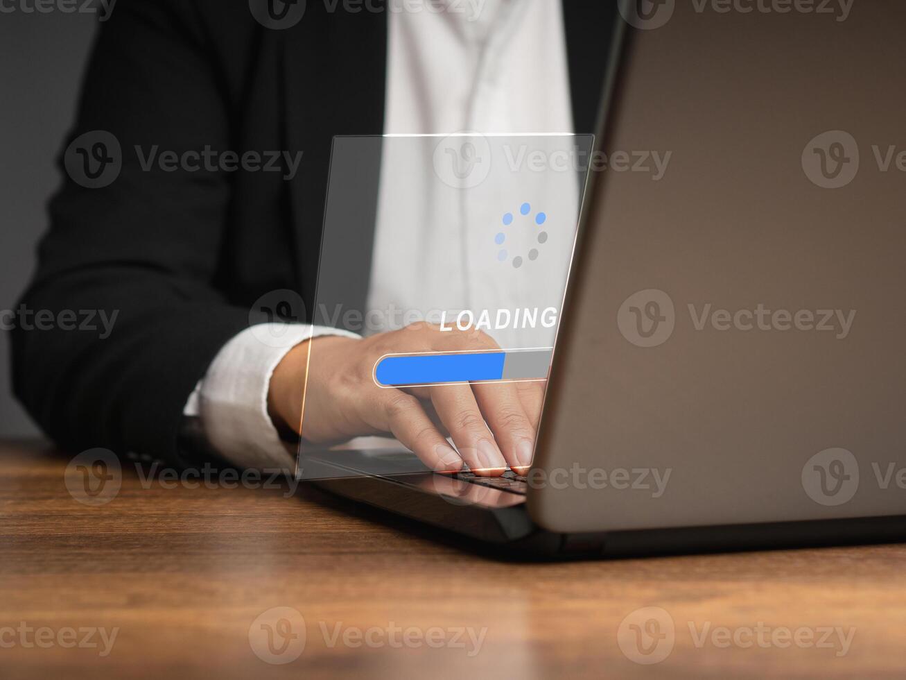 Businessman in a suit uses a laptop for loading and processing data on a virtual screen photo