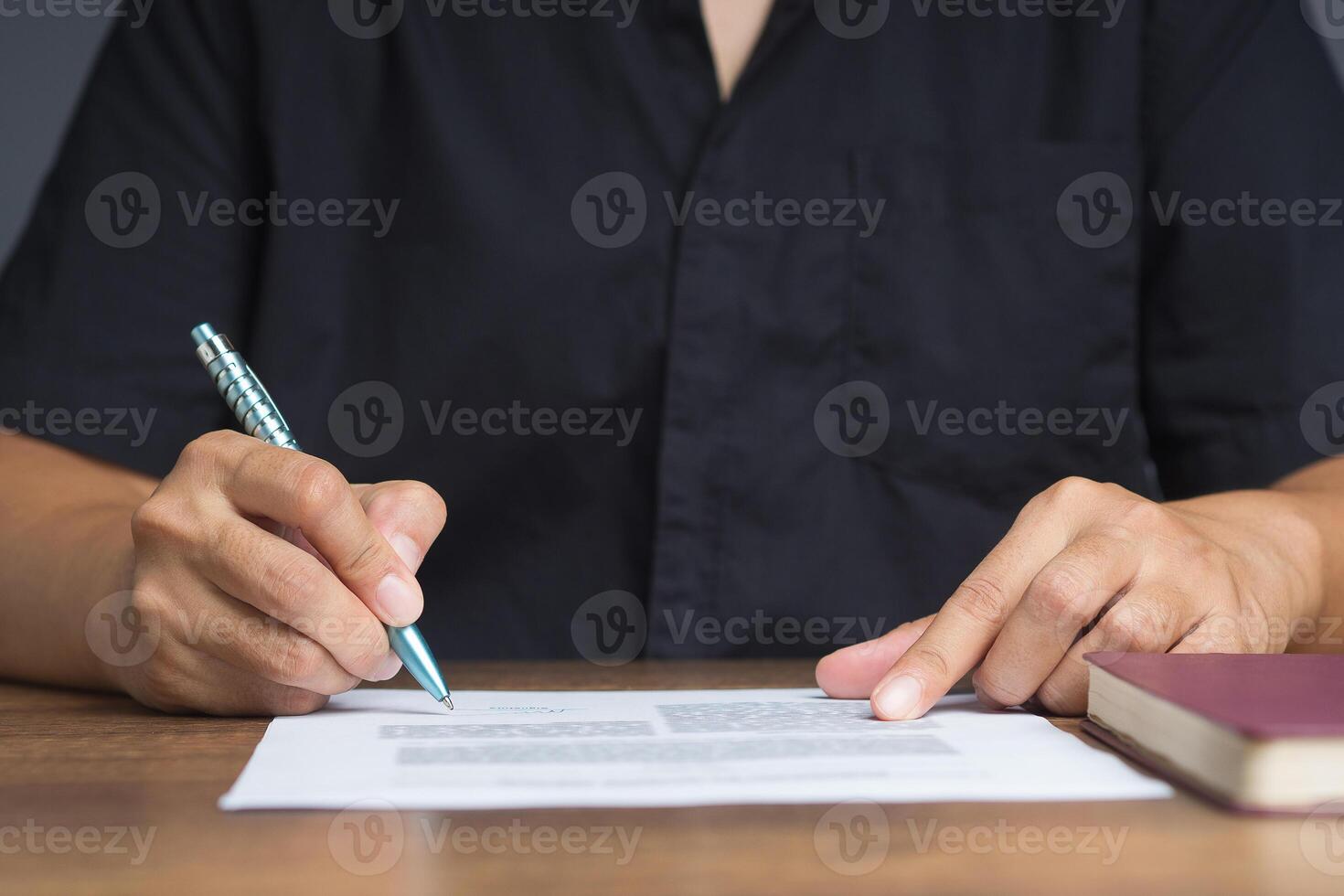 Businessman signing a contract or agreement while sitting at the table in the office. photo