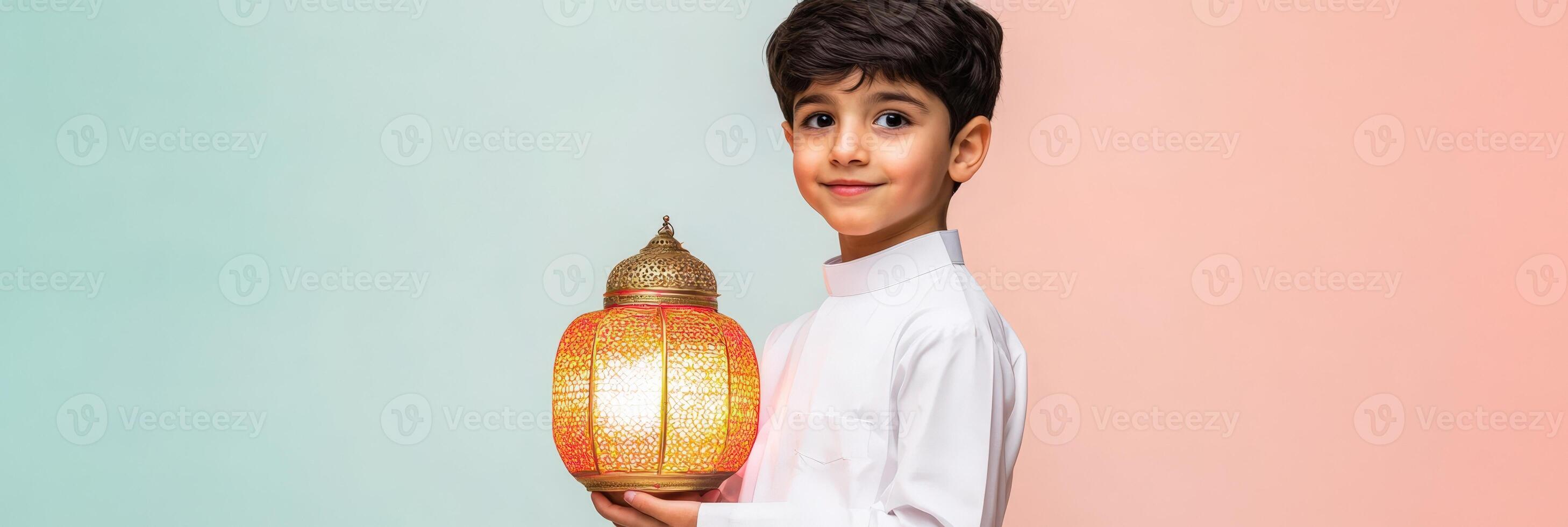 A boy in a traditional muslim outfit holding a lamp. photo