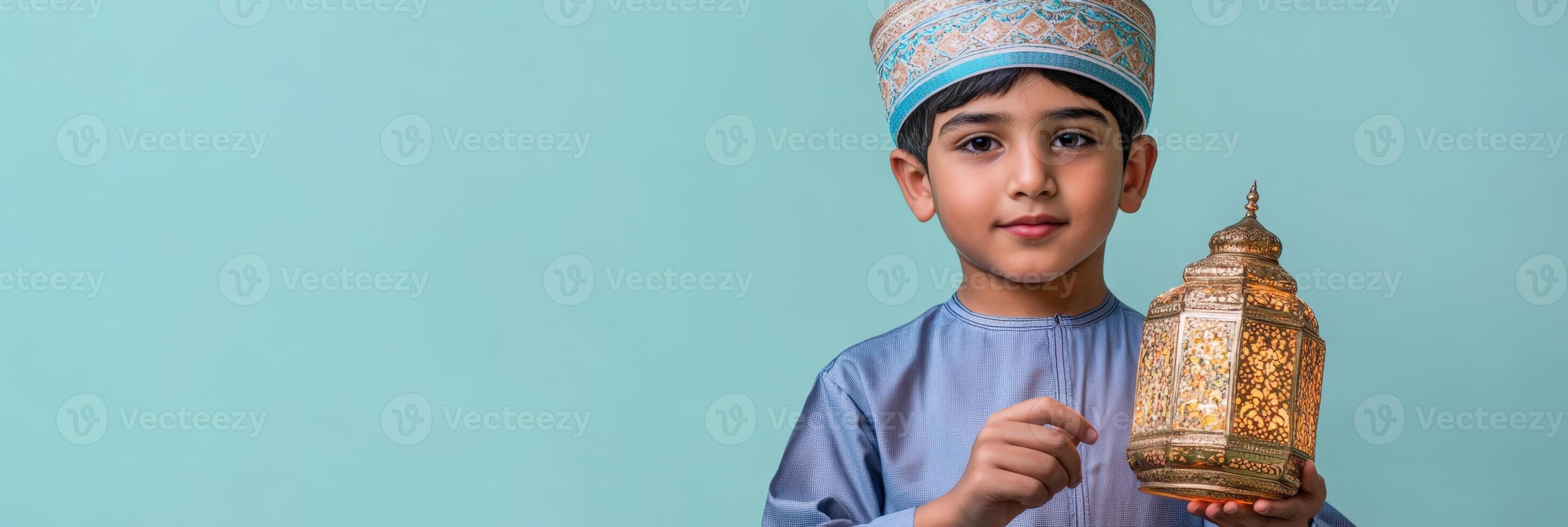 A young boy in a traditional muslim outfit holding a lamp. photo
