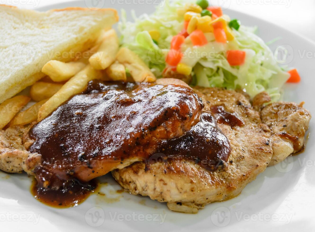 Grilled pork steak fillet with salad and French fries photo