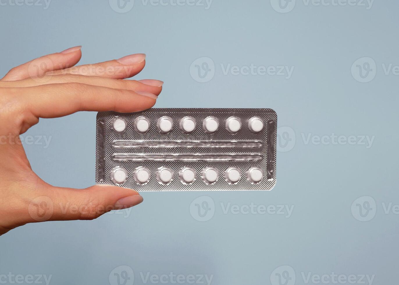 A blister of pills in a woman's hand close up. Background banner with copy space for text photo