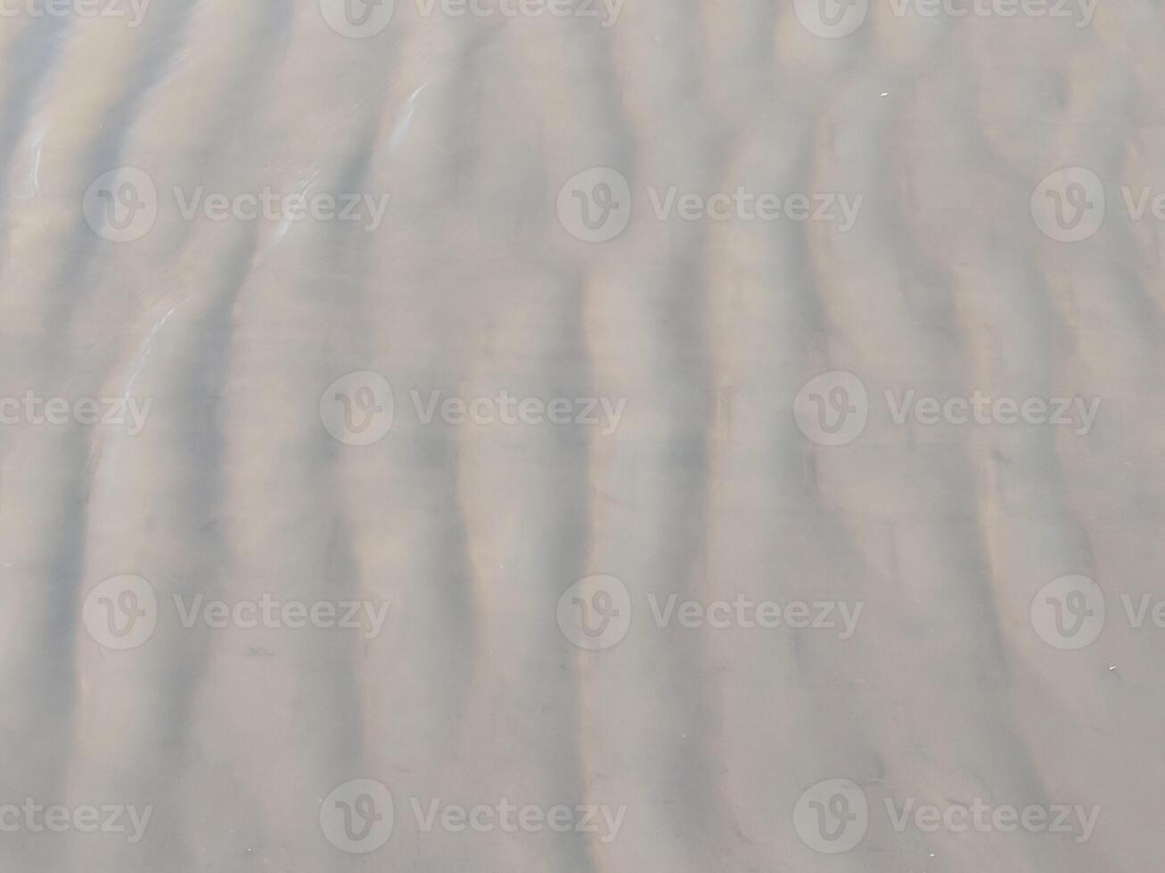 A man is walking on the beach with a surfboard photo