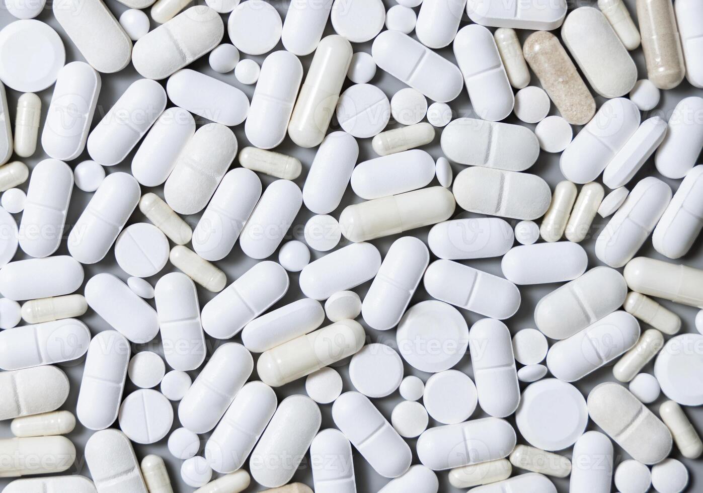 Mix of medical capsules and pills on grey top view. Taking dietary supplements and medicines photo