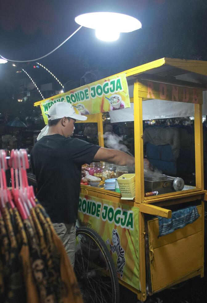 A street food vendor preparing Ronde Jogja at a night market in Indonesia. photo