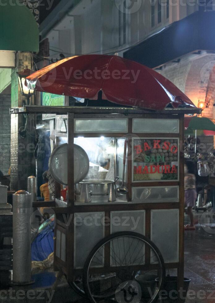 Indonesian Bakso Street Food Cart with Red Umbrella at Night in Yogyakarta, Indonesia photo