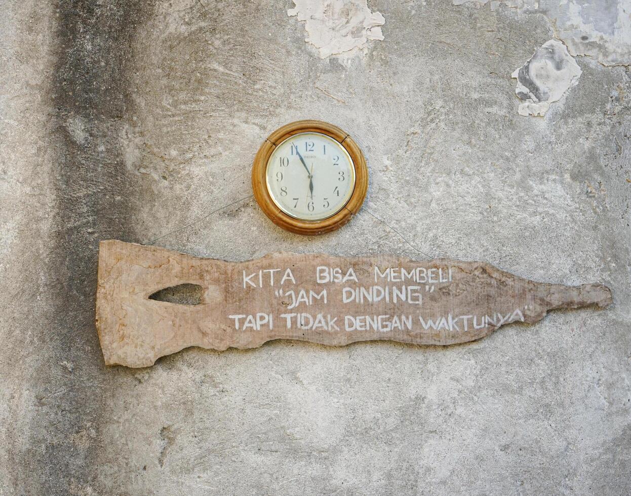 Clock and Inspirational Quote on a Weathered Wall photo