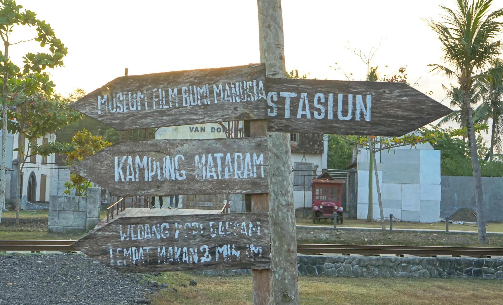 Wooden Signpost with Directions in Indonesian photo