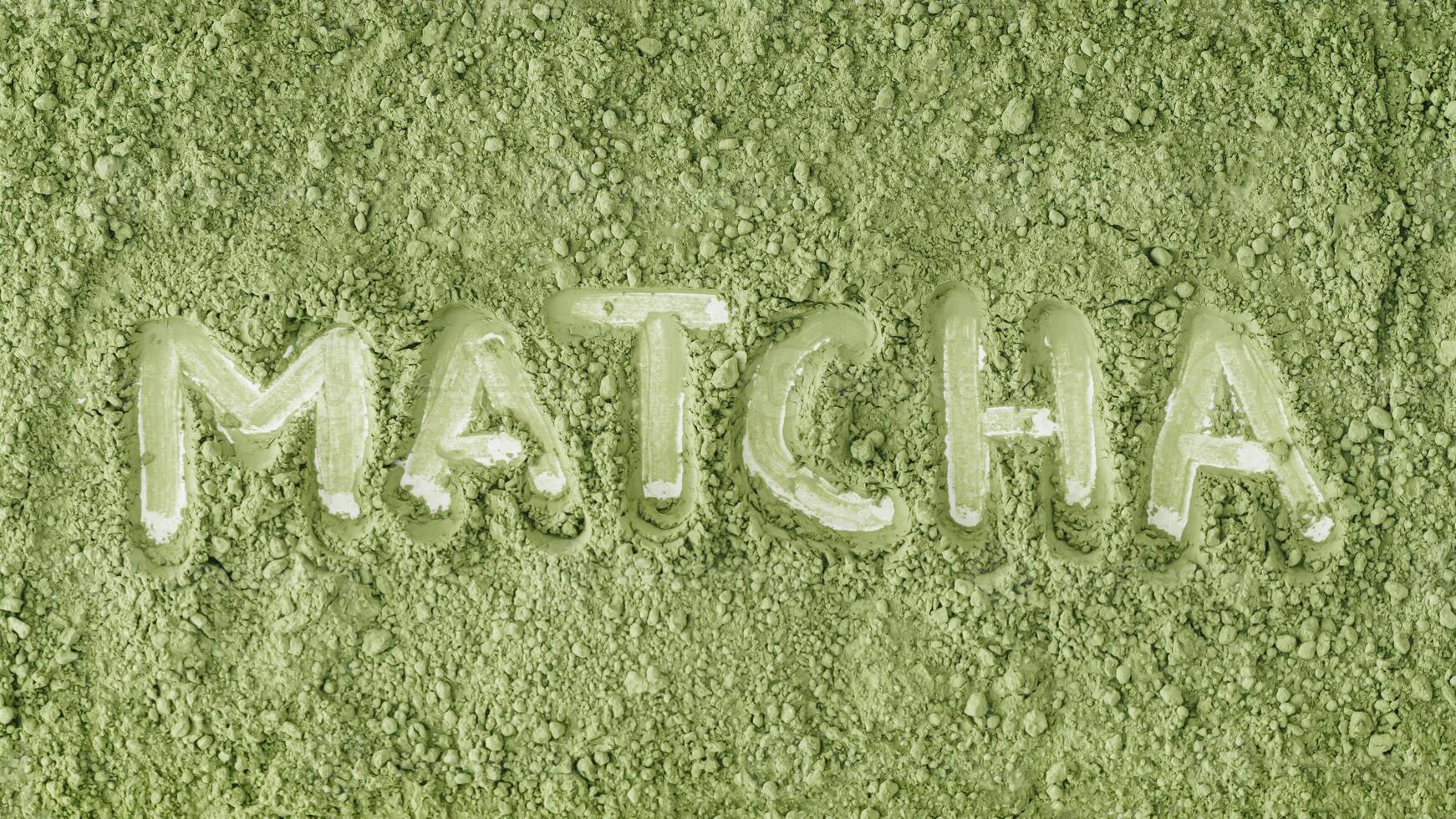 Top view of organic matcha powder with MATCHA text written in powder. Minimal healthy drink concept. Trendy japanese green tea idea. Flat lay style. photo