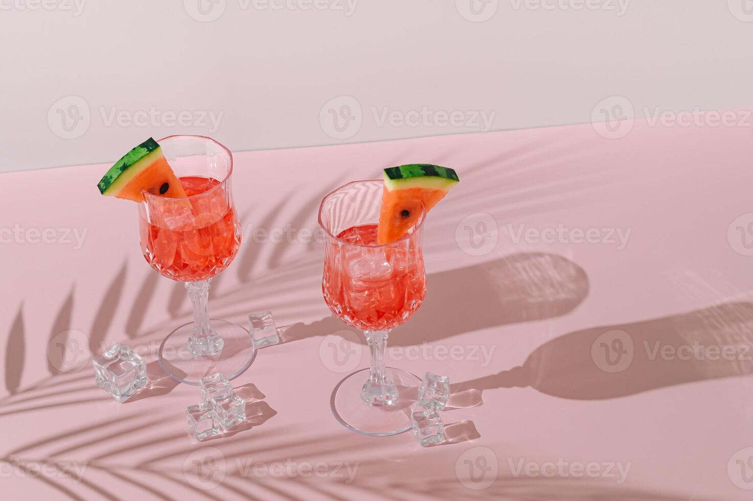 Summer scene with refreshing watermelon drink and palm tree leaves shadow on pink and white background. Sun and shadows. Minimal cocktail concept. Trendy summertime party idea. Summer aesthetic. photo