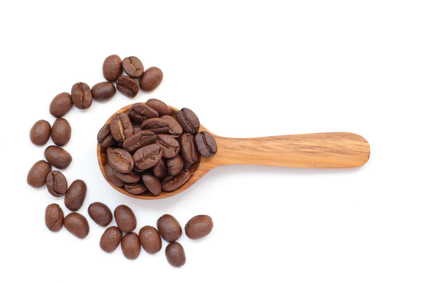 Spoon with coffee, coffee beans on a wooden spoon isolated on white background photo