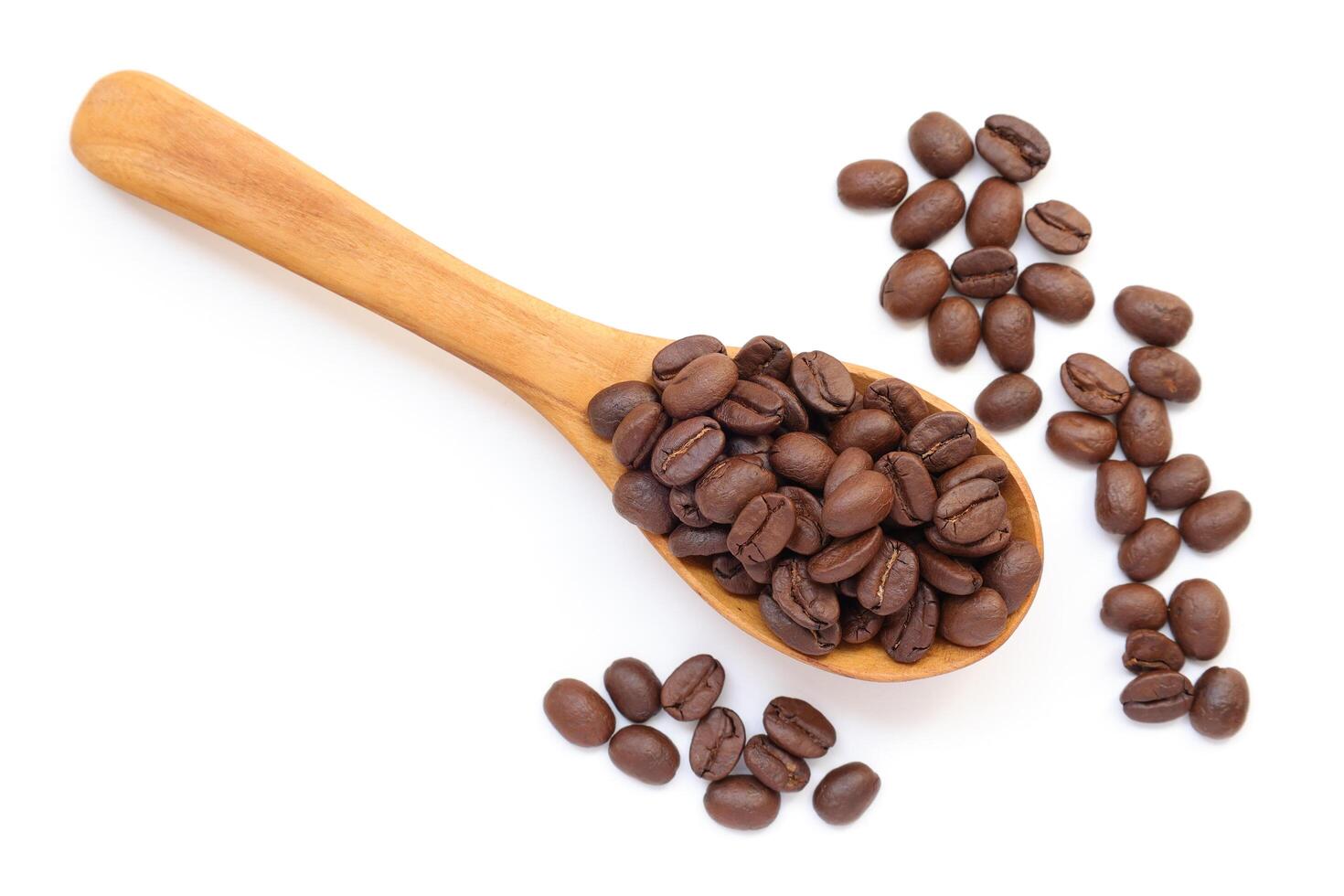 Coffee beans in spoon, brown roasted coffee beans in wooden spoon on white background, isolated of coffee beans photo