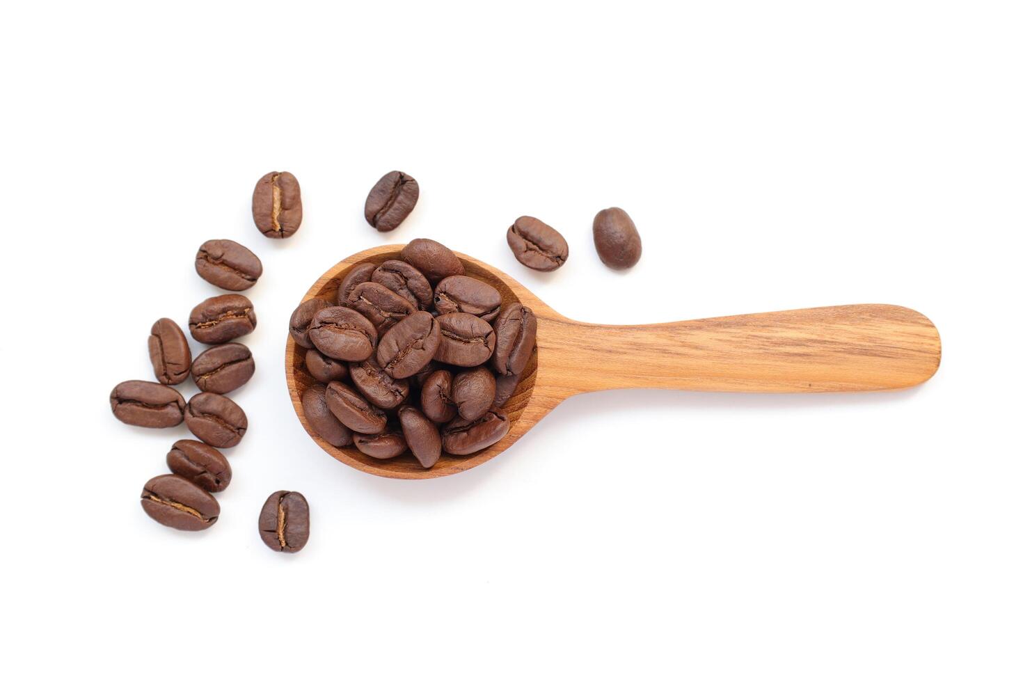 Coffee beans in spoon, brown roasted coffee beans in wooden spoon on white background, isolated of coffee photo