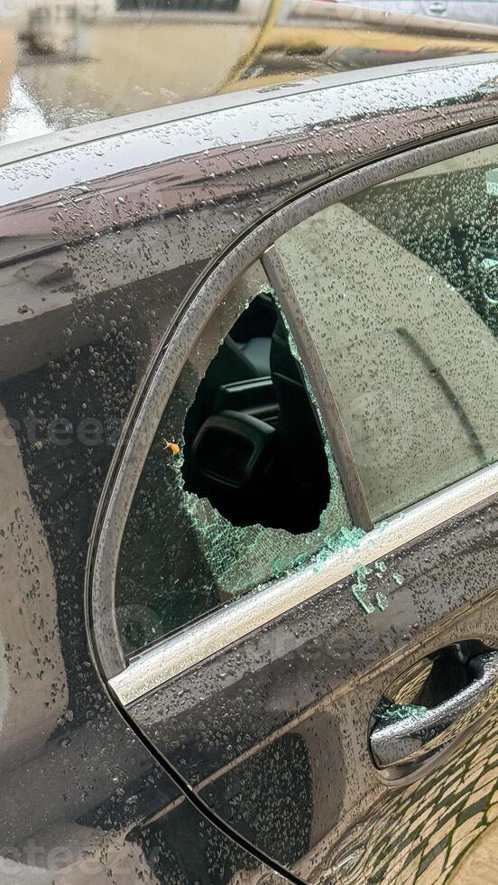 Shattered window whispers urban mystery, shards glistening like stars, unexpected tales for Nuit Blanche or Car Security Awareness Week photo