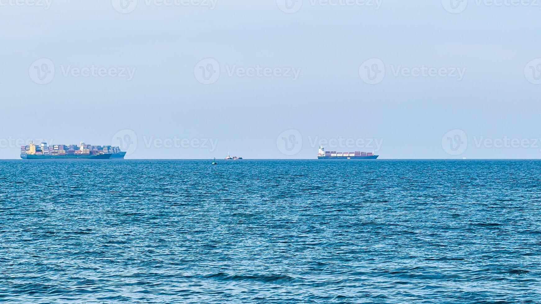Vast oceans blue expanse cradles distant cargo ships like whispers of trade, echoing International Maritime Days global connectivity photo