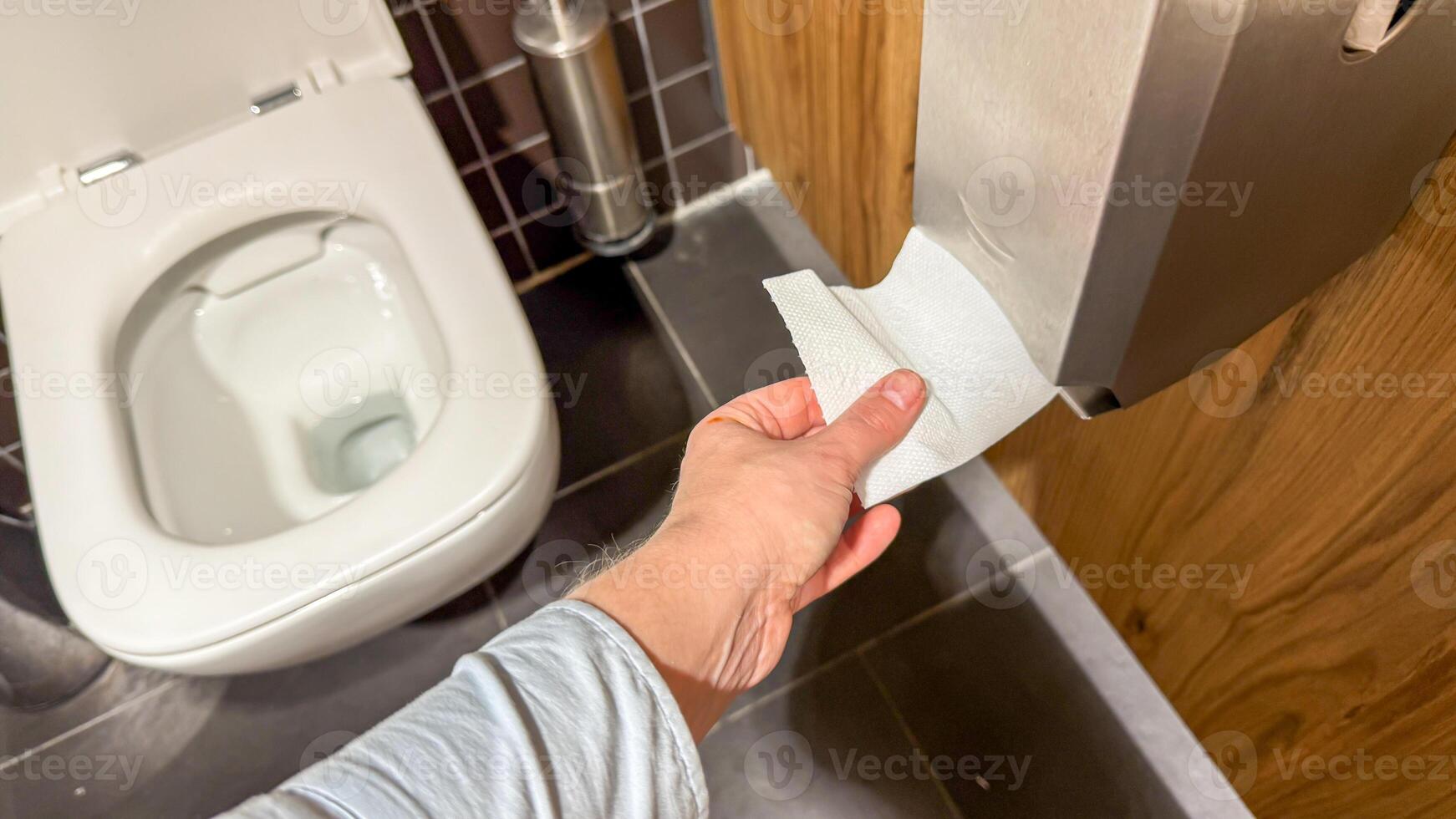 A hand reaches for toilet paper in a zen like restroom, evoking Global Handwashing Day and Hygge home rituals photo
