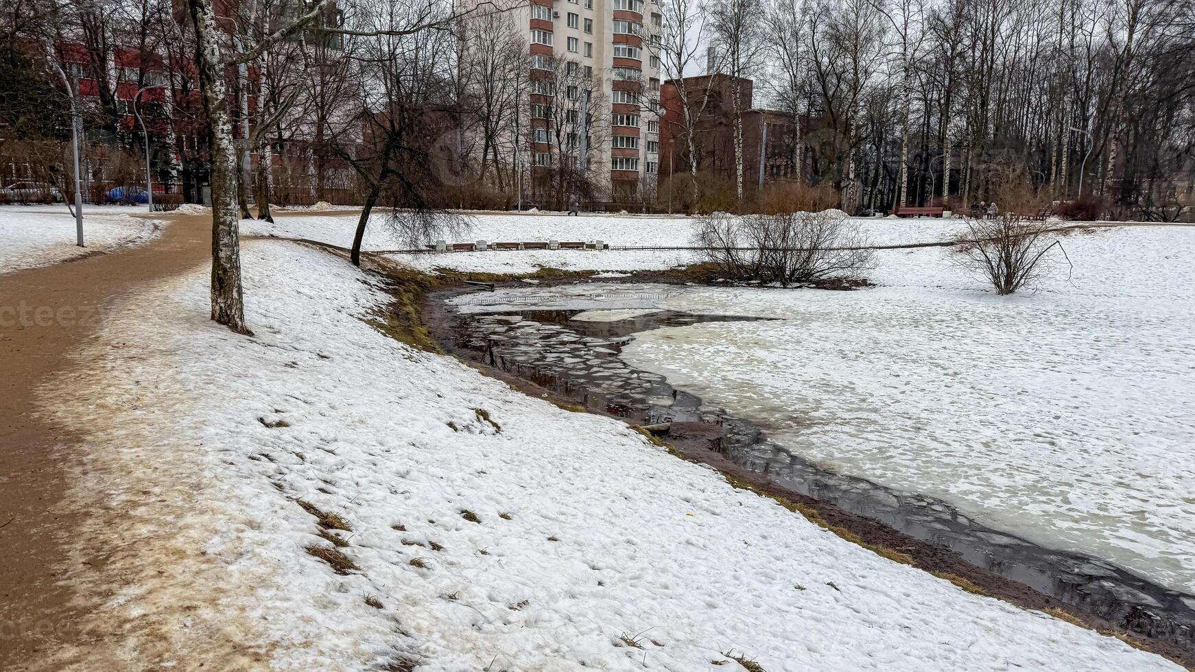 Serpentine whispers of thawing snow cradle winding stream in urban tundra, perfect for Slavic Maslenitsa festivities photo