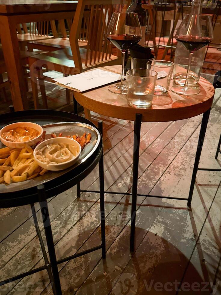 Cozy cafe ambiance with unfinished fries and swirling red wine, perfect for solitary musings or Diwali dinner reflections photo