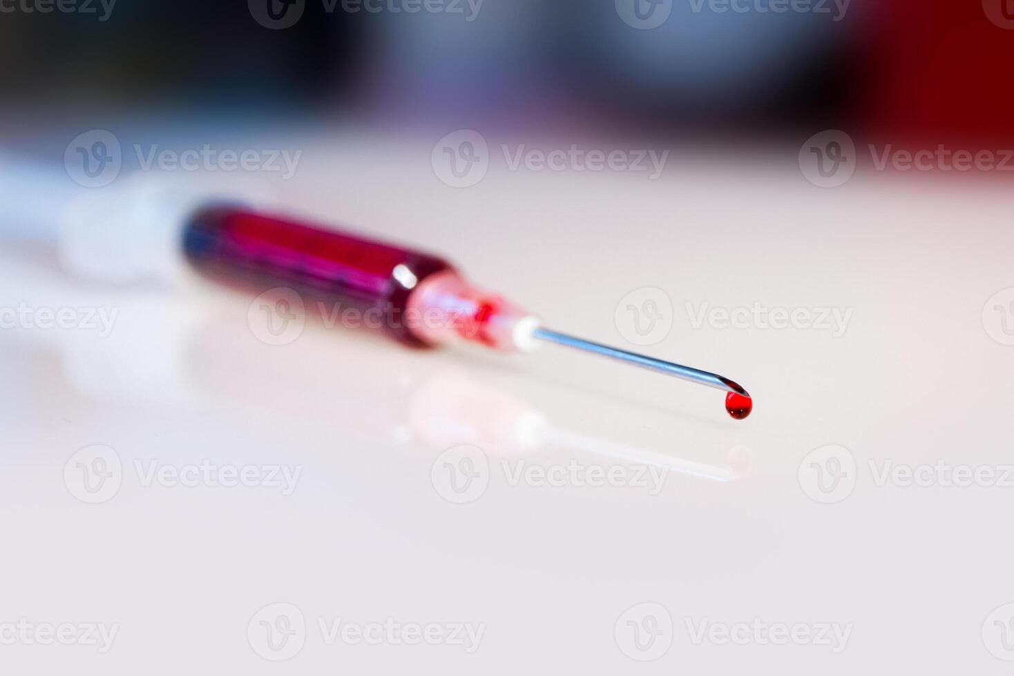 Syringe needle with blood macro view photo