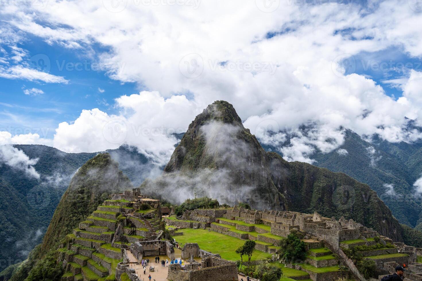 Panoramic view of Machu Picchu ruins surrounded by misty mountains, Peru photo