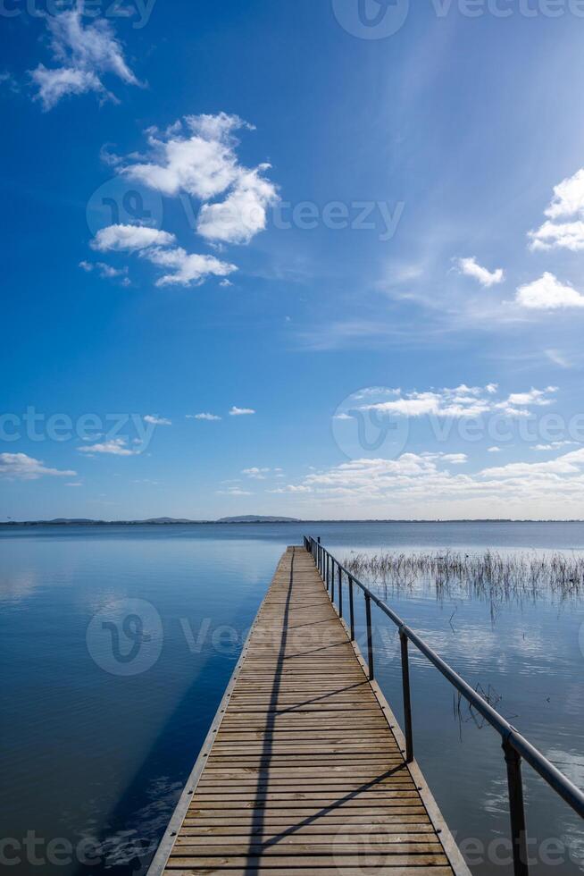 Wooden pier extending over Lake Colac, Victoria, Australia on a sunny day photo