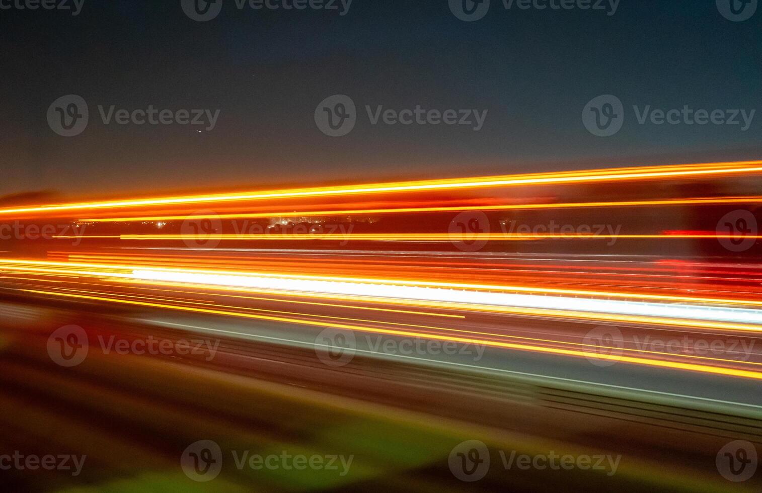 Light trails of a moving vehicle at night on the road photo