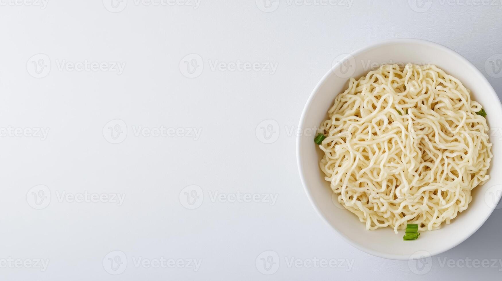 Freshly cooked instant noodles with green onion garnishes in a white bowl on a clean white background perfect for Asian cuisine food images and quick meal concepts photo