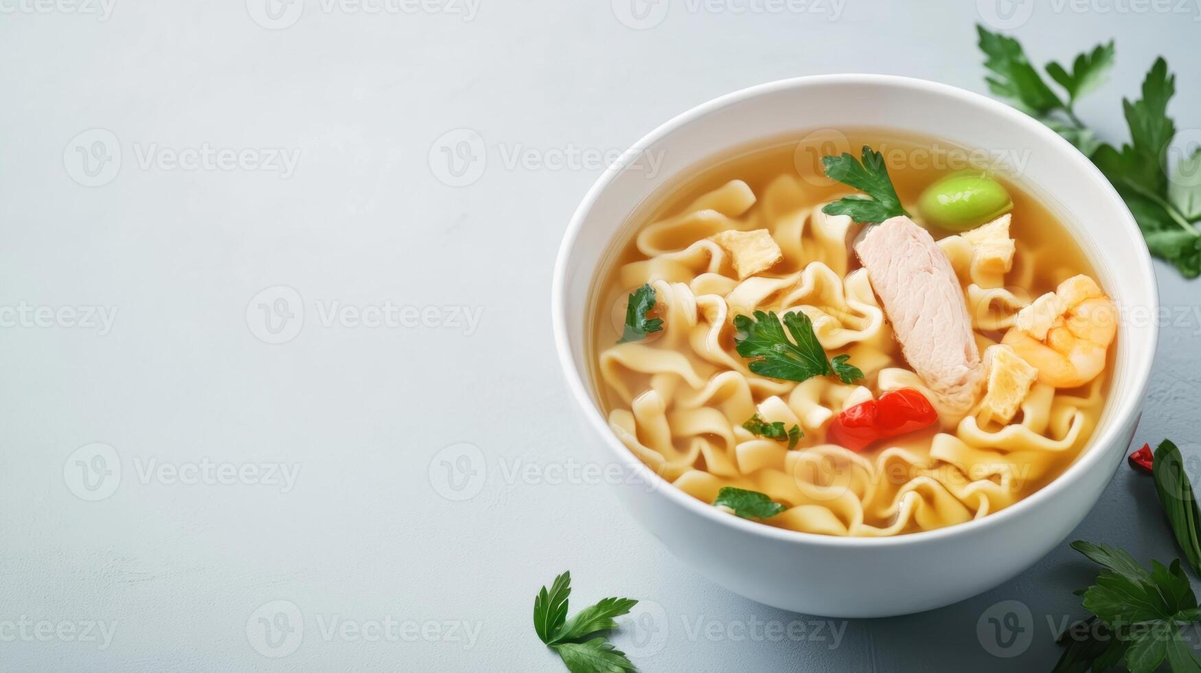 Close-up of a white bowl filled with steaming chicken noodle soup with vegetables and herbs on a white surface, fresh parsley garnished for flavorful comfort food photo