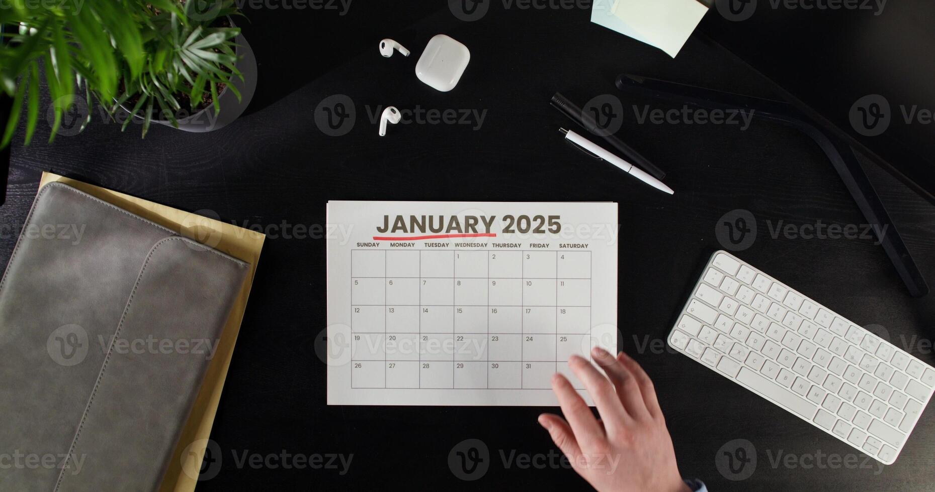woman highlights date in a calendar while sitting at a table. Planning while working in the office. Close-up photo
