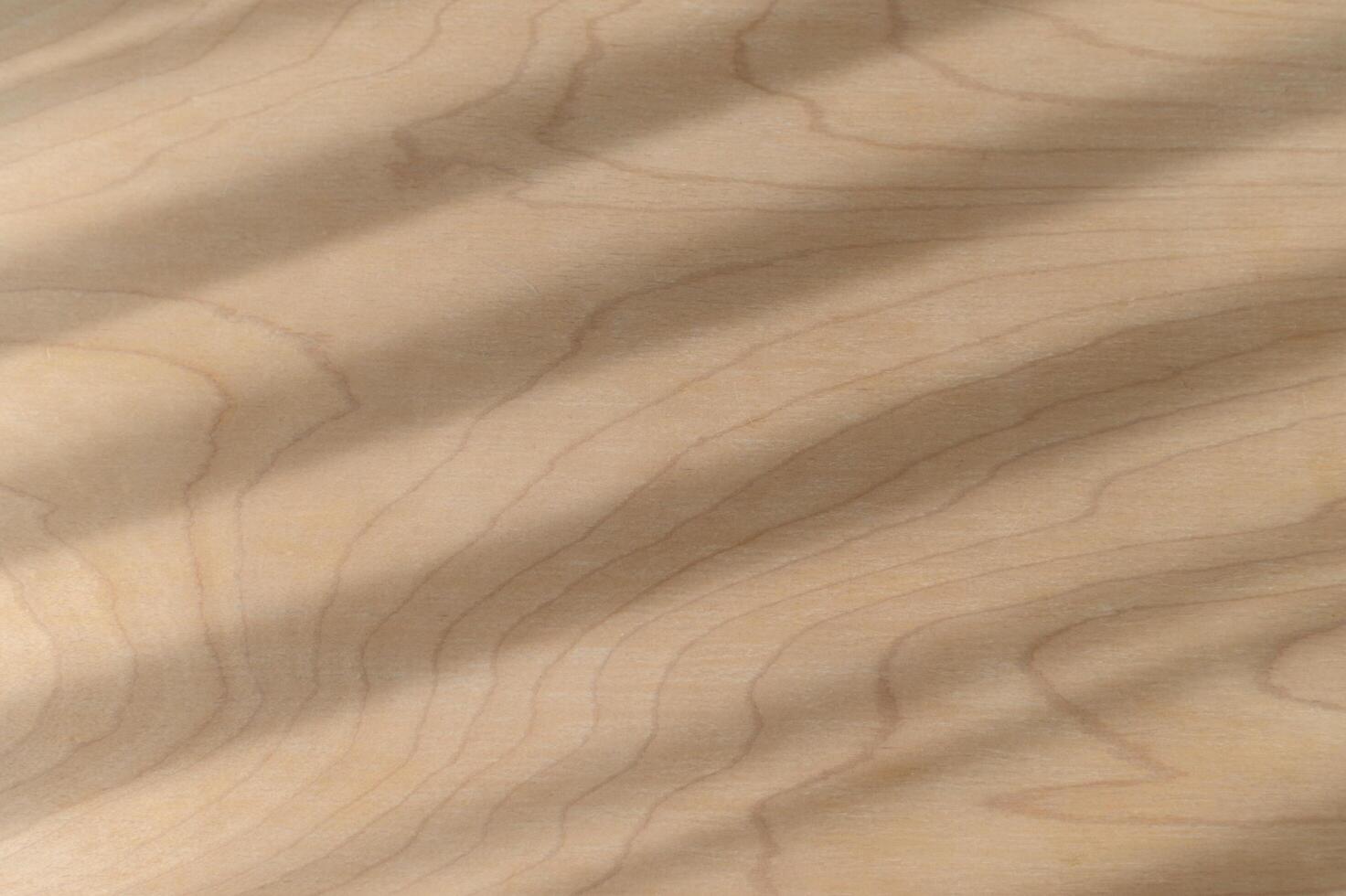 Natural wood texture features diagonal shadows and parallel light stripes creating an abstract background pattern on smooth brown surface. detail shows subtle wood grain of organic material photo