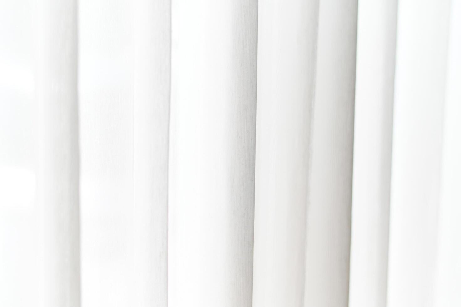 Abstract white textile background features soft vertical folds and subtle shadows creating clean elegant pattern ideal for design backdrop or copy space photo