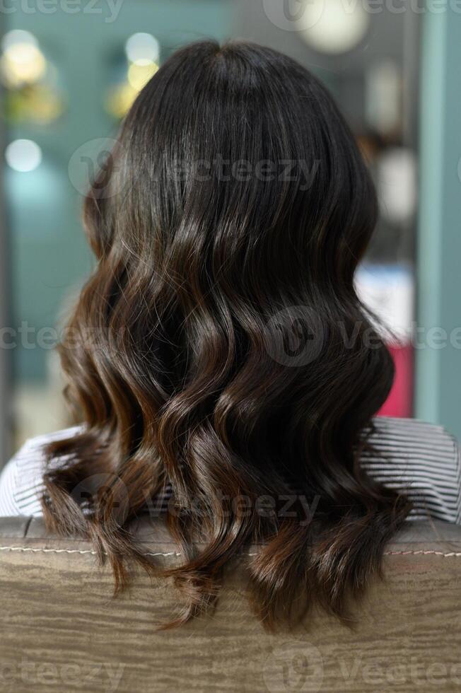 Young southeast asian woman customer receiving hair dyeing service at salon feels relaxed embracing wellness healthcare within beauty treatment photo