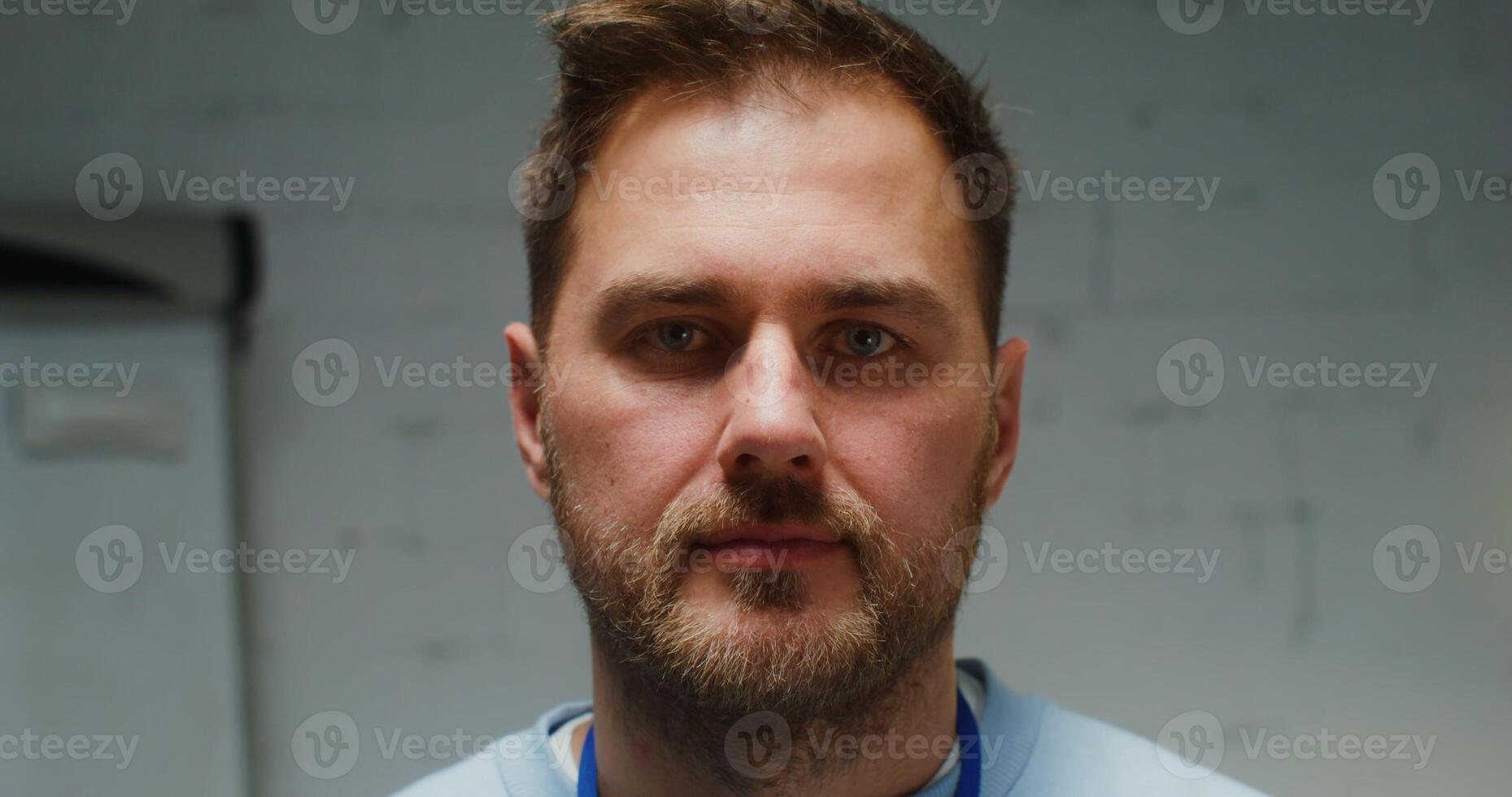 Handsome young man of European appearance with a short beard smiling looking straight into the camera, close up of a male face photo
