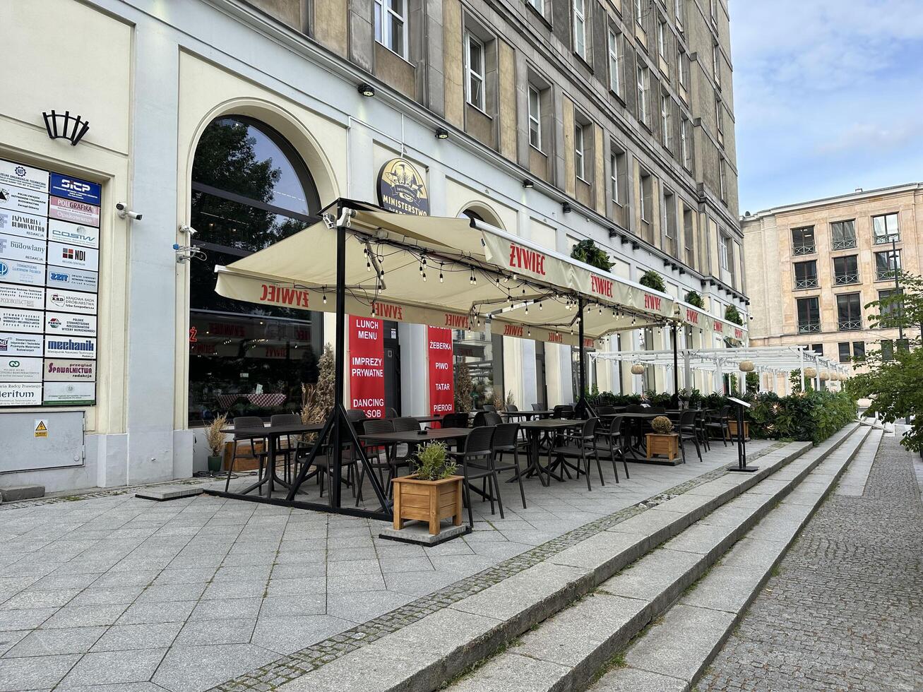 Warsaw, Poland - May 22, 2025 Outdoor dining area of a vibrant restaurant with stylish seating and umbrellas, showcasing a lively atmosphere in an urban setting photo