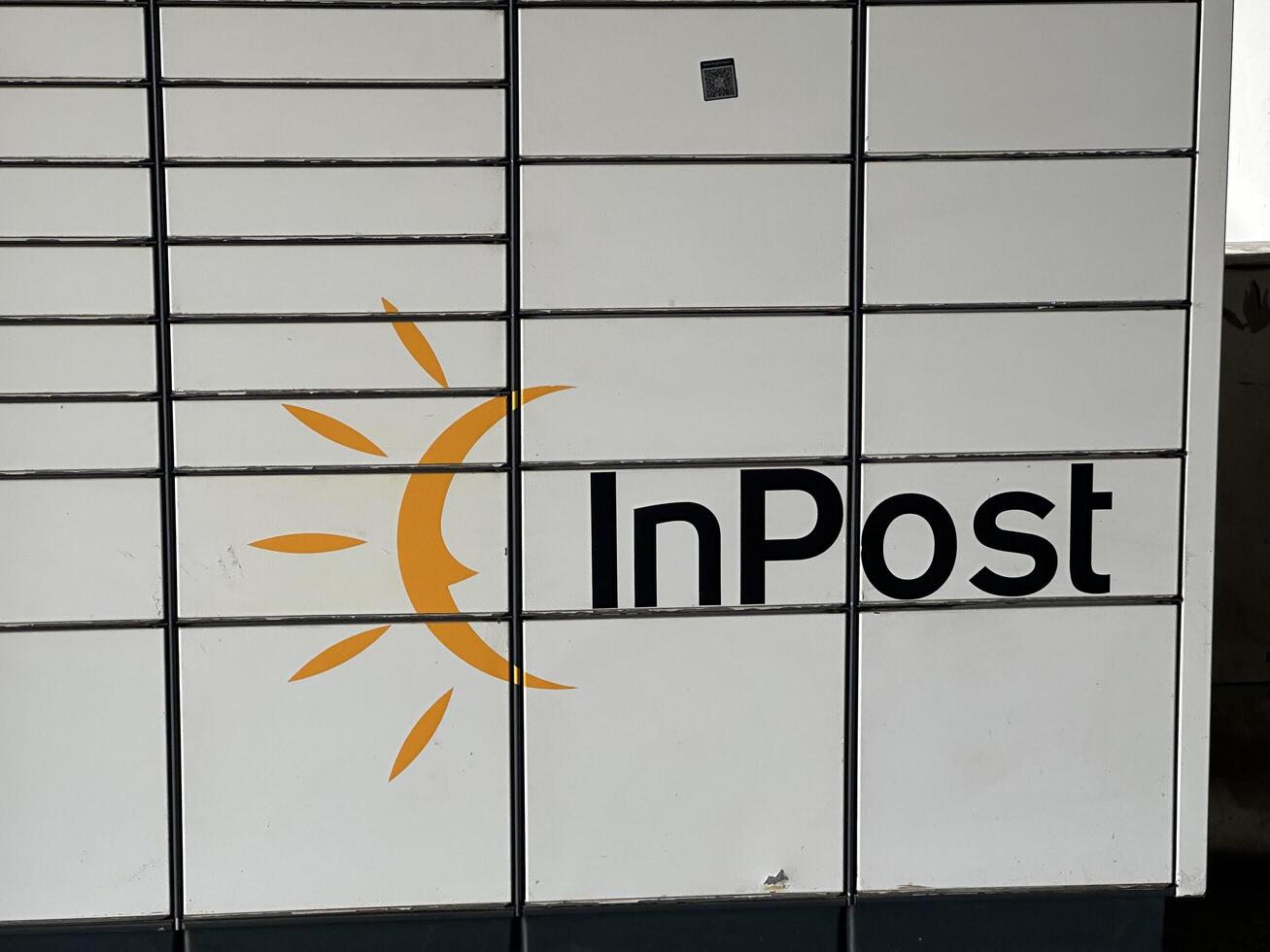 Warsaw, Poland - May 22, 2025 InPost parcel locker with bright sun logo, showcasing modern delivery solutions and convenience for users in urban environments photo