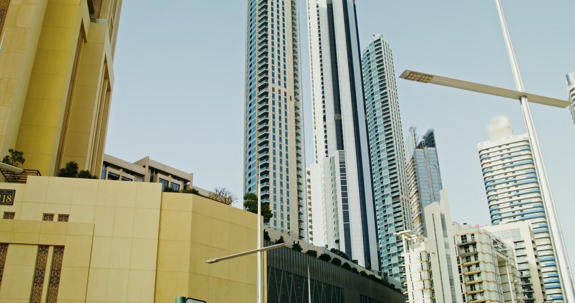Dubai, UAE, 2025- Overview of modern glass skyscrapers in the business center of the city. the moves from the bottom up to the top of the building, sunny day photo
