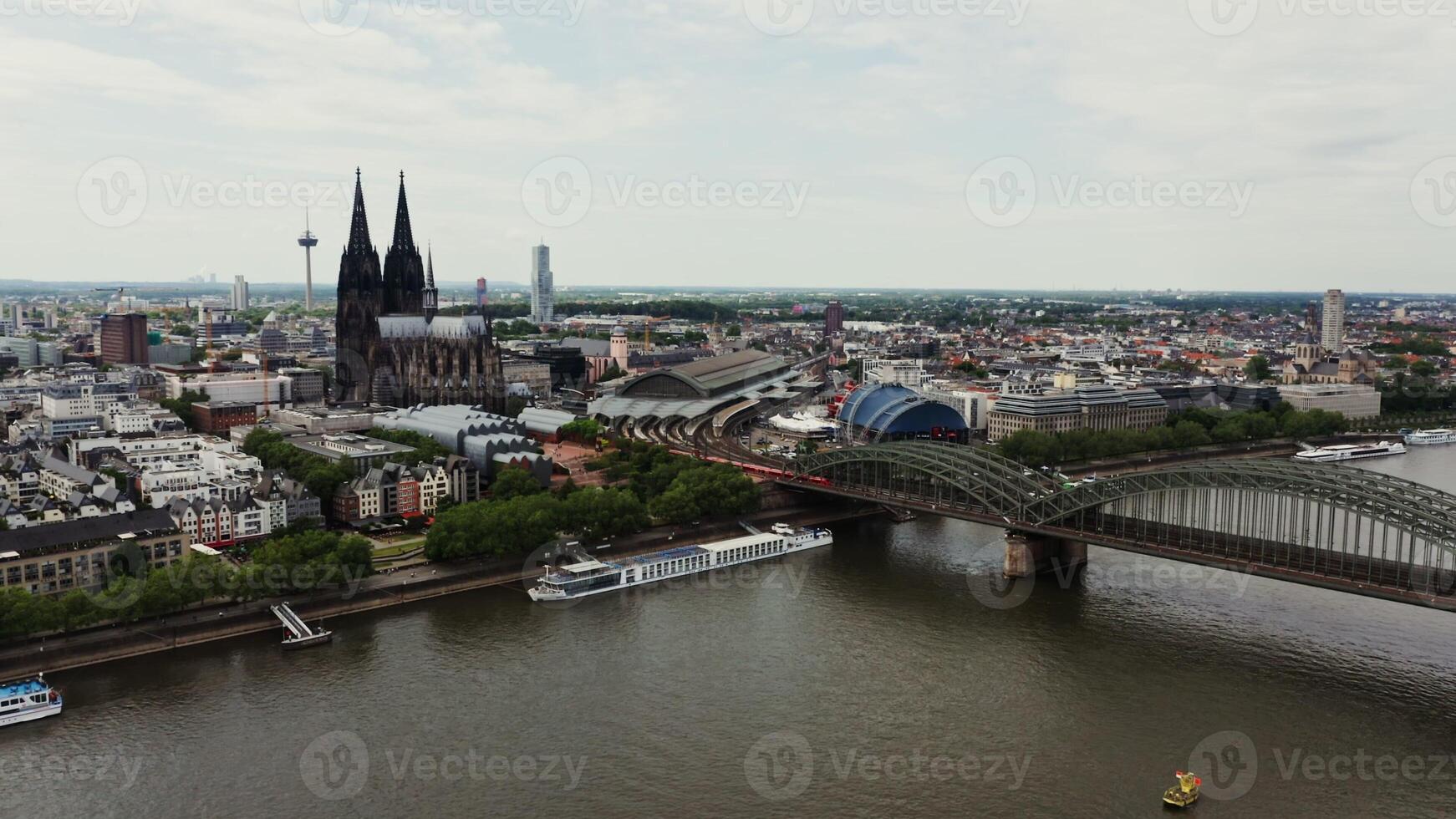 Panoramic drone shot, view of the historical center of Cologne with the Gothic Cologne Cathedral. Bird's eye from the side of the railway bridge on which the train travels. photo