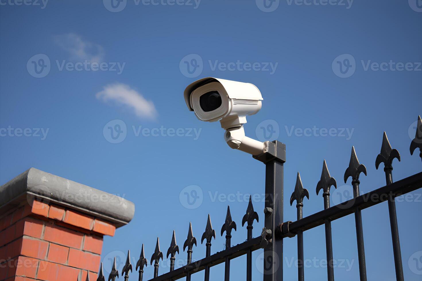 White security camera monitoring a residential area with blue sky photo