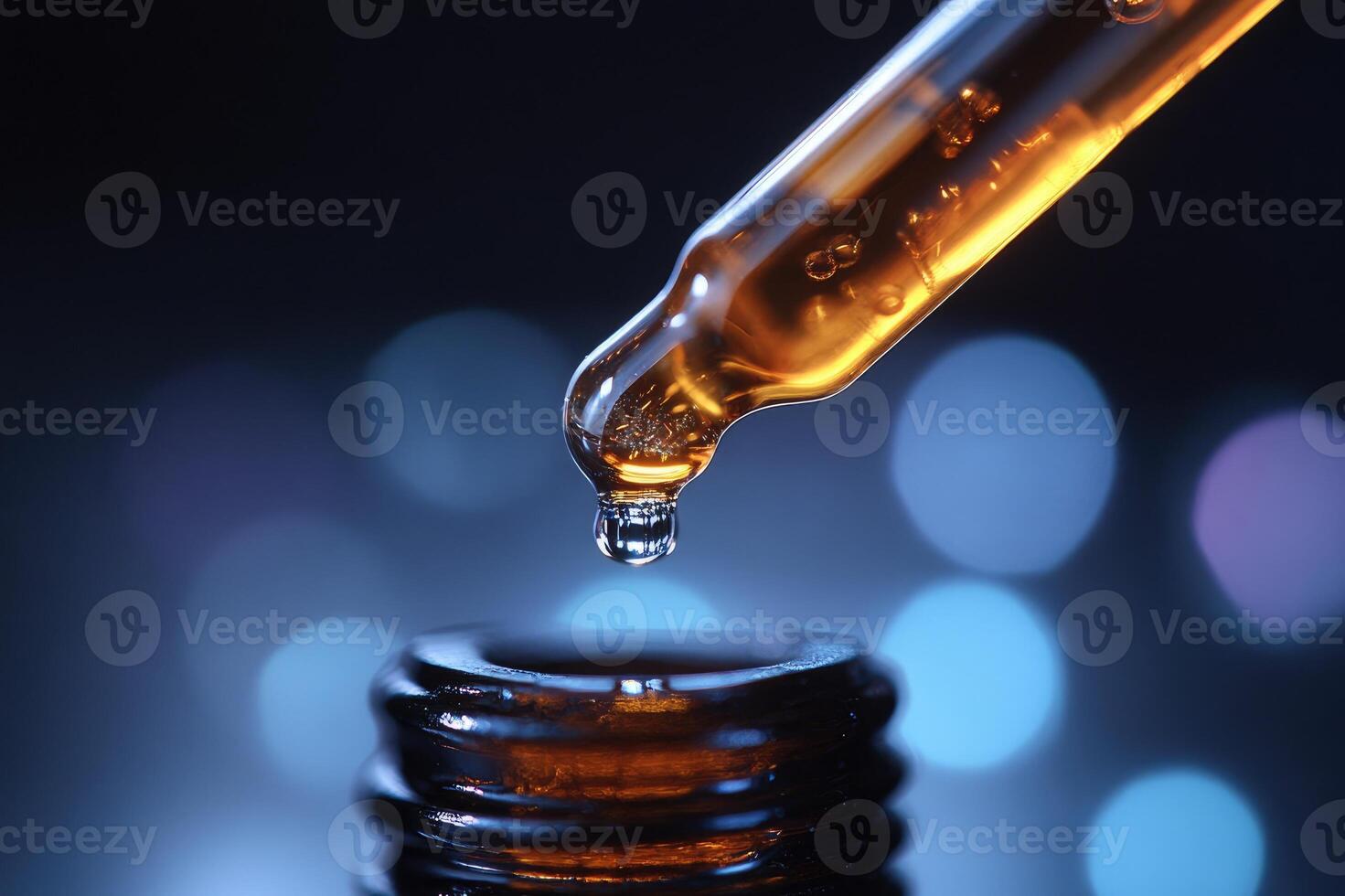 Pipette dripping essential oil into bottle with bokeh lights photo